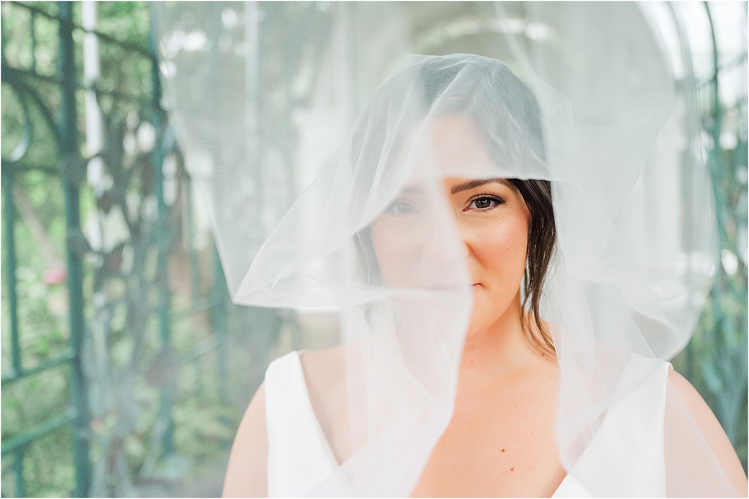 bride looking through wedding veil • Wild Weather - Love at a Phipps Conservatory Outdoor Garden Wedding